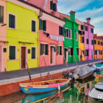 a row of colorful painted houses on the river with boats