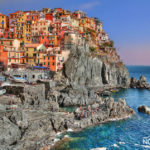 The colorful villages of Cinque Terre with people on the shores