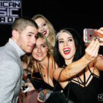 nick jonas taking pictures with fans at the american music awards