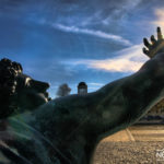 statue with a raised hand towards the sun