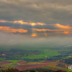 sun rays shinging through the clouds on the agriculture fields of the golan heights