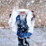 Jewish worshiper at Western Wall in jerusalem taking cover from the snow