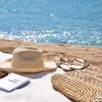 straw hat and white blanket on the beach
