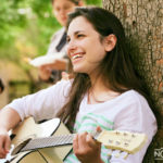 woman playing a guitar outside