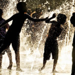 silhouette of children playing in a water fountain
